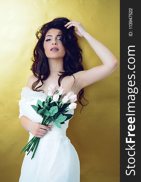 Woman In White Strapless Wedding Gown Standing In Front Of Yellow Surface