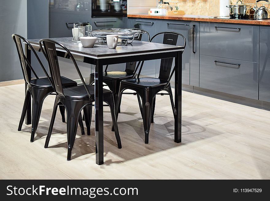 White Ceramic Mug on Black Dining Table With Four Chair Set