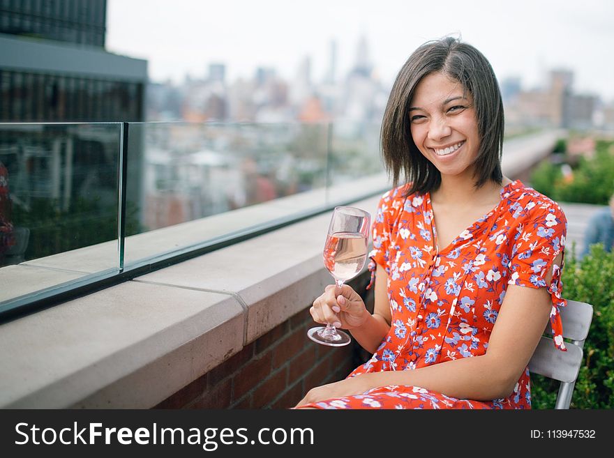 Photo of a Woman Sitting on Chair Holding Wine Glass