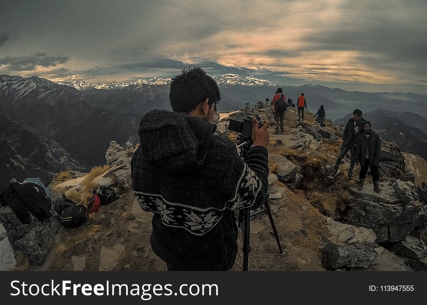 Man Taking Photo of Couple on Mountain Range