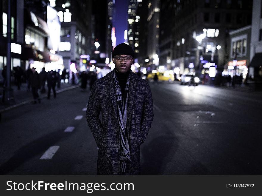 Man Wearing Gray Coat Standing In The Middle Of The Road