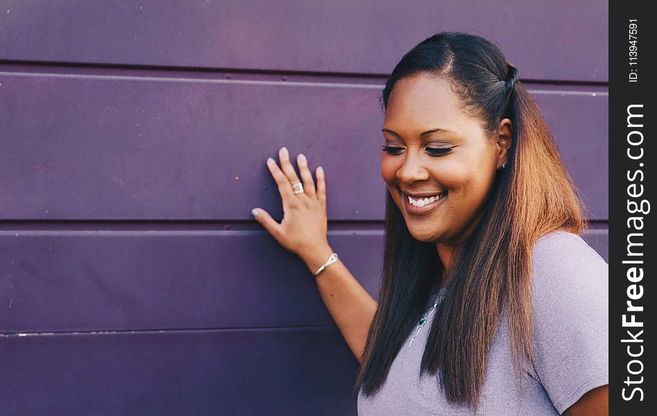 Woman Standing Touching Gray Wall Wearing Gray Shirt