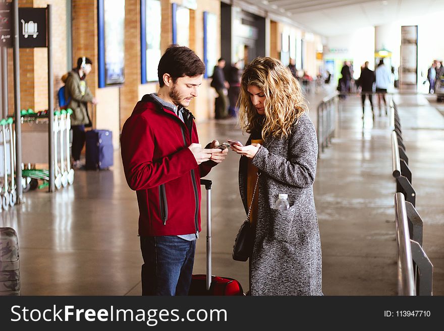 Photo of Man and Woman Using Their Phones