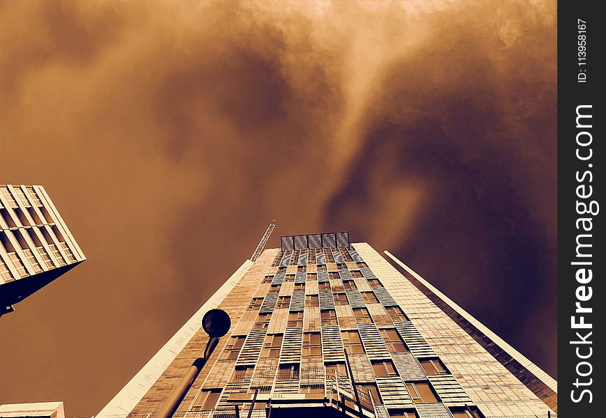 Low-angle Photography Of Brown Concrete Building Under Brown Clouds