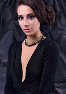 Studio Portrait Of Young Beautiful Woman In Evening Dress. Necklace Around Her Neck Royalty Free Stock Photography