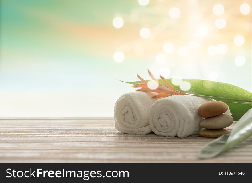 Spa treatment concept. towel,massage oil and spa stones with bokeh nature background. Spa treatment concept. towel,massage oil and spa stones with bokeh nature background.