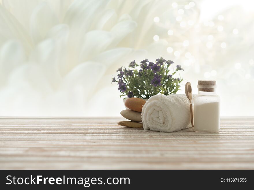 Spa treatment concept. towel,salt spa and spa stones with white flowers background. Spa treatment concept. towel,salt spa and spa stones with white flowers background