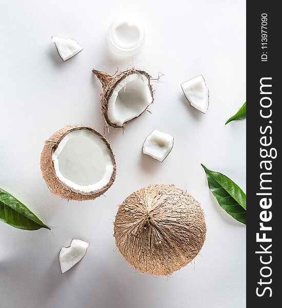 Homemade coconut cosmetic with coconut and green leaf on white background. from top view