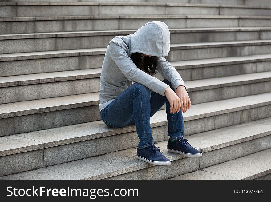 Upset woman sitting alone in city stairs