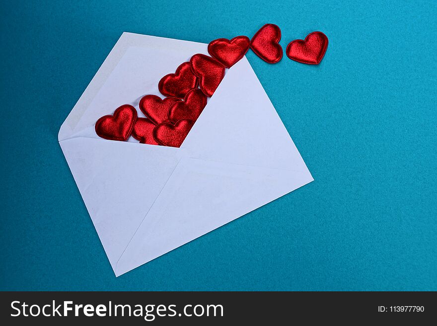 Big white open envelope with red hearts lies on a blue background