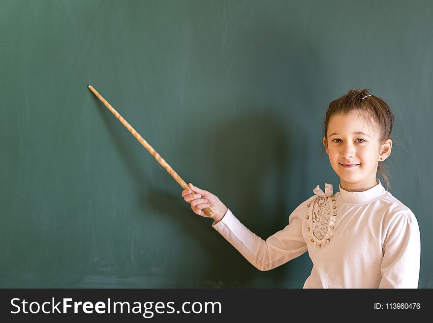 schoolgirl near the board with a pointer