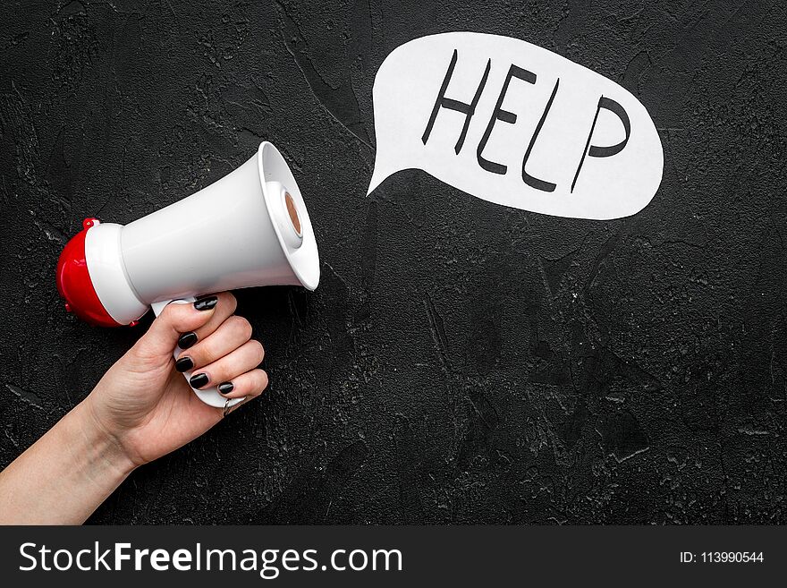 Call for help concept. Megaphone near cloud with word help on black background top view. Call for help concept. Megaphone near cloud with word help on black background top view.