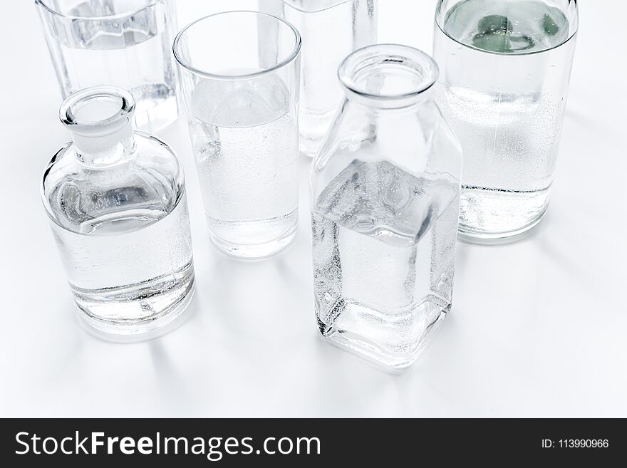 Drinks on the table. Pure water in jar and glasses on white background.