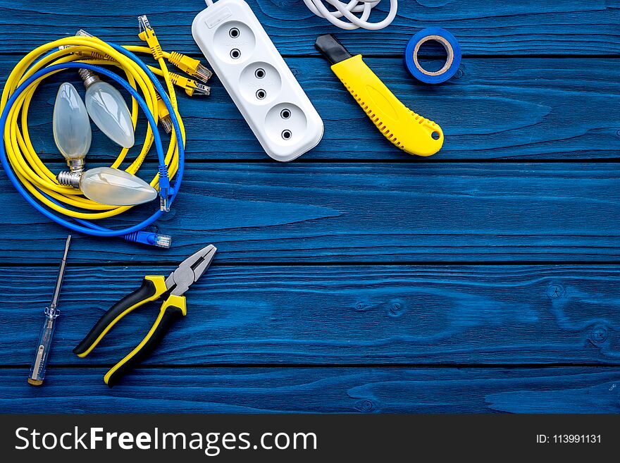 Electrical Repair. Bulbs, Socket Outlet, Cabel, Screwdriver, Pilers On Blue Wooden Background Top View Copy Space