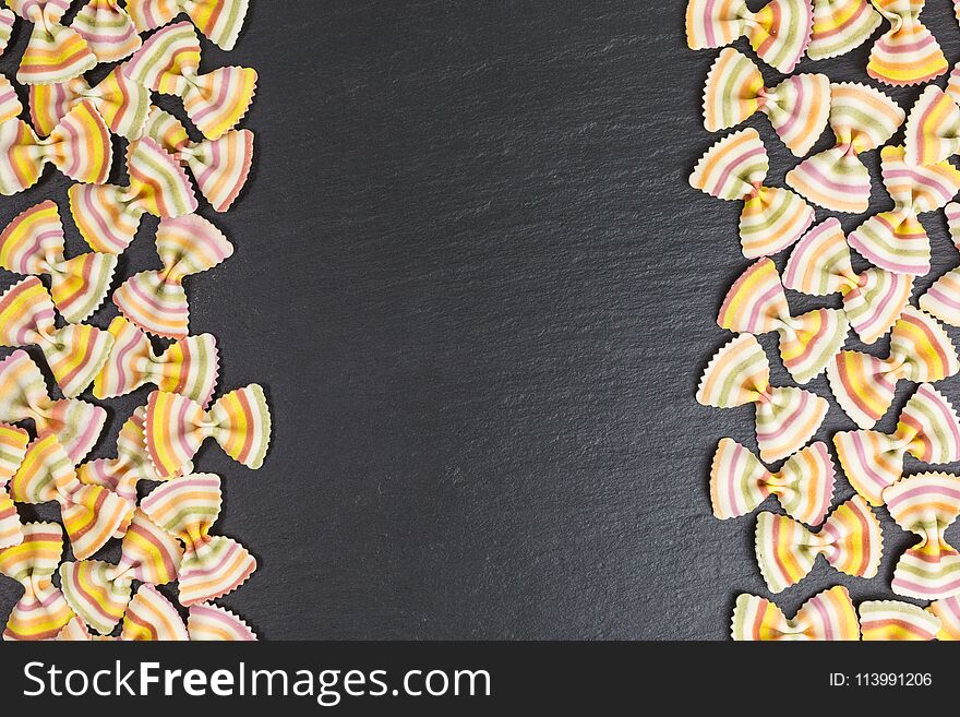 Multicolored raw pasta farfalle with copy space