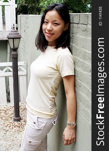 Pretty Korean woman leaning on a wall