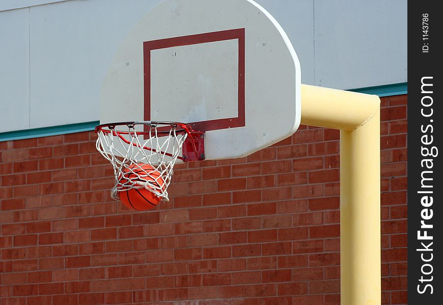 The basketball sweeps through the basketball hoop net. The basketball sweeps through the basketball hoop net.