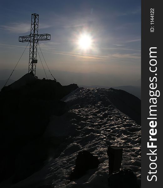 Mountain summit with cross and sun