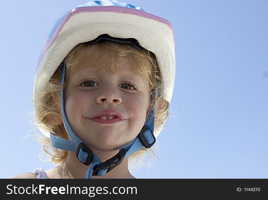 A cute little curly haired blond girl with her bicycle helmet on. A cute little curly haired blond girl with her bicycle helmet on.