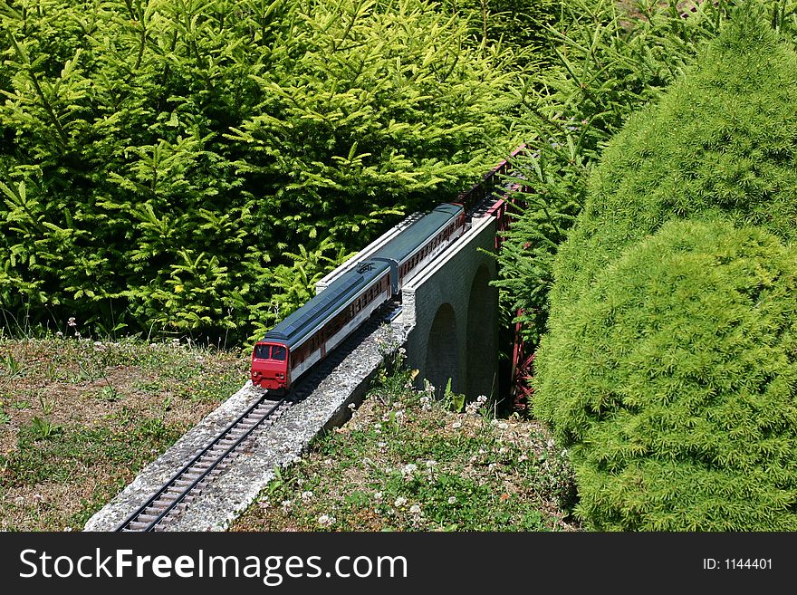 Model of train between miniature firs