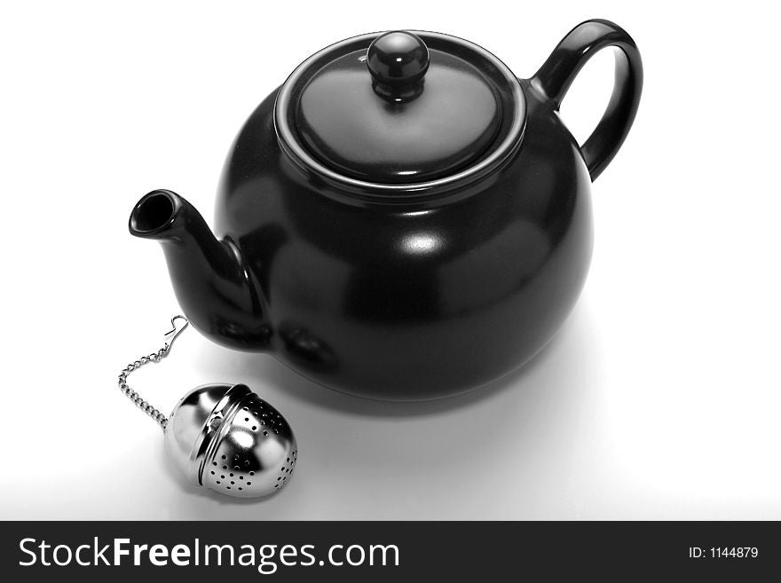 Black teapot and metal tea infuser.