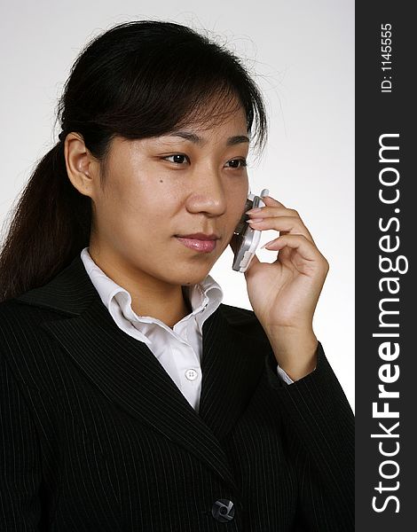 An asian girl talking on the phone'. An asian girl talking on the phone'