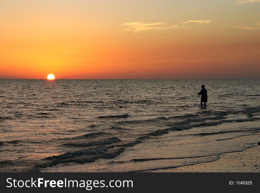 A sport fisherman watches the sunset. A sport fisherman watches the sunset