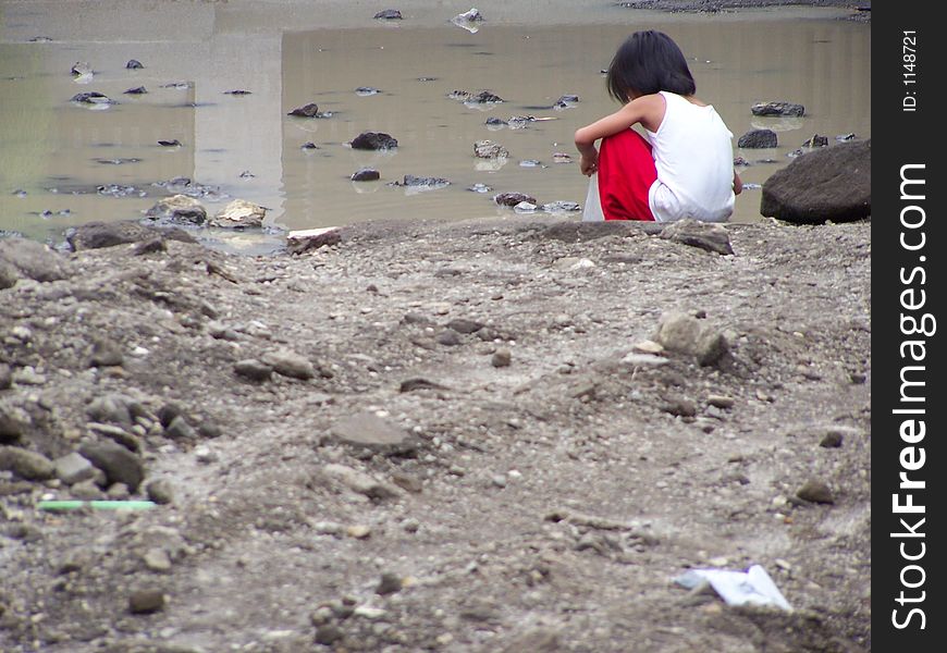 A little girl playing in a mud puddle. A little girl playing in a mud puddle