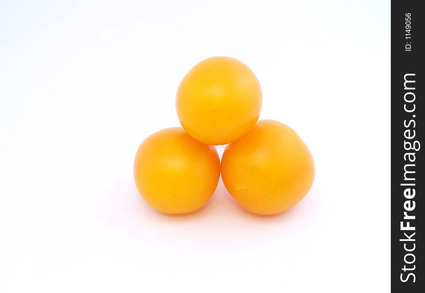 Three yellow tomatoes on the white. Three yellow tomatoes on the white
