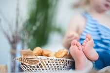 A Little Girl In A Vest With A Vest Sits On The Table. Focus On Children`s Legs Stock Images A Little Girl In A Vest With A Vest Sits On The Table. Focus On Children`s Legs Stock Images