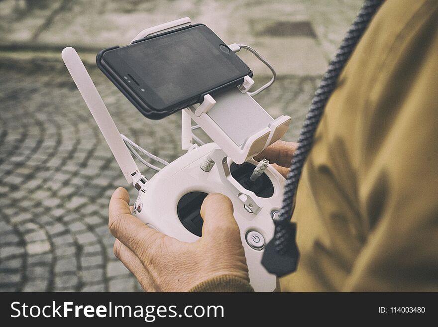 White remote control in arm, dron fly. White remote control in arm, dron fly