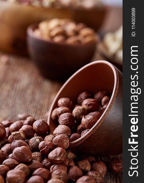 A composition from different varieties of nuts in a wooden bowls on rustic background, close-up, shallow depth of field