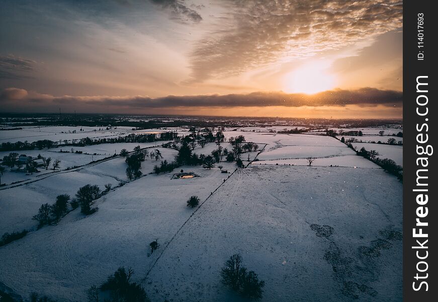 Drone shot of the sky sunset clouds land trees landscape snow