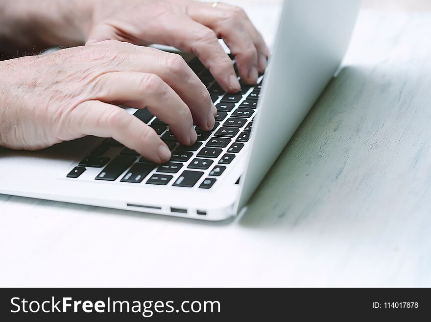 Close up view of senior hands on the keyboard of computer laptop. Technology concept. Close up view of senior hands on the keyboard of computer laptop. Technology concept