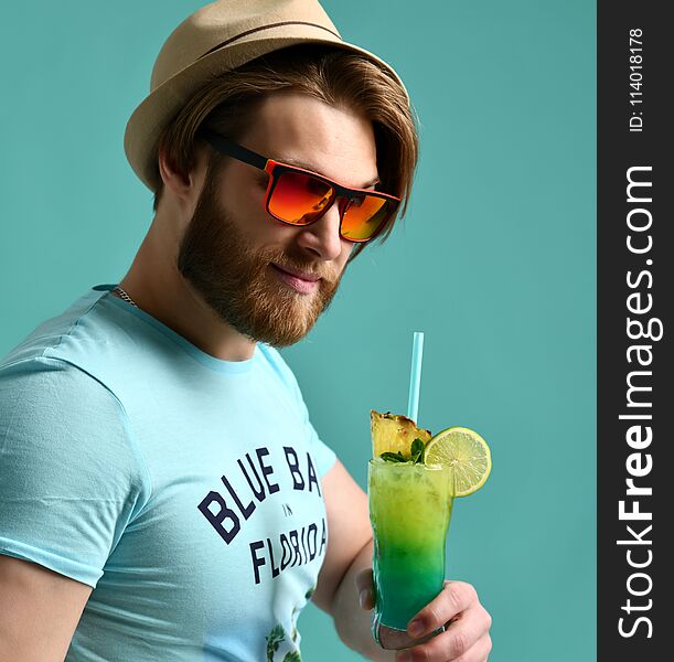 Young man in hat drinking margarita cocktail drink juice happy looking at camera