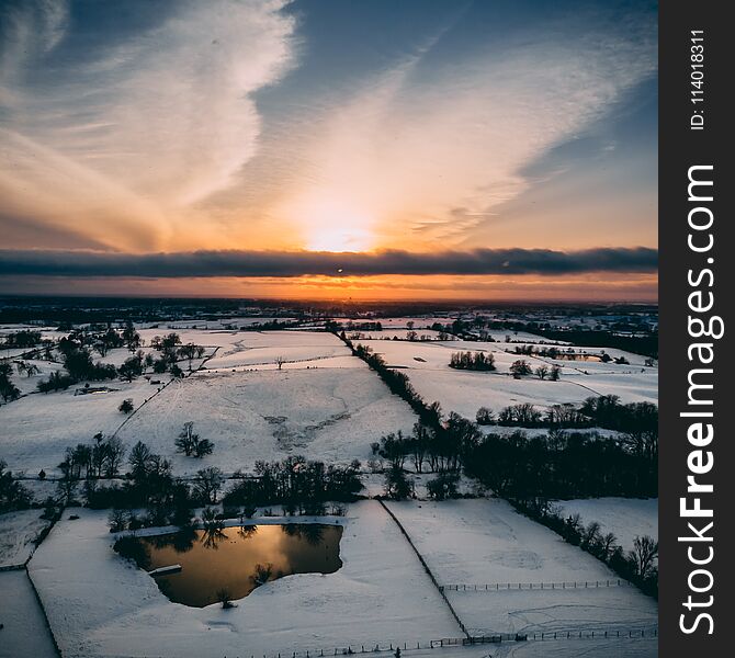 Drone shot of the sky sunset clouds land trees landscape snow