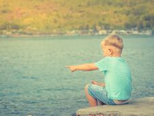 Cute Caucasian Boy Pointing At Seaside Royalty Free Stock Images