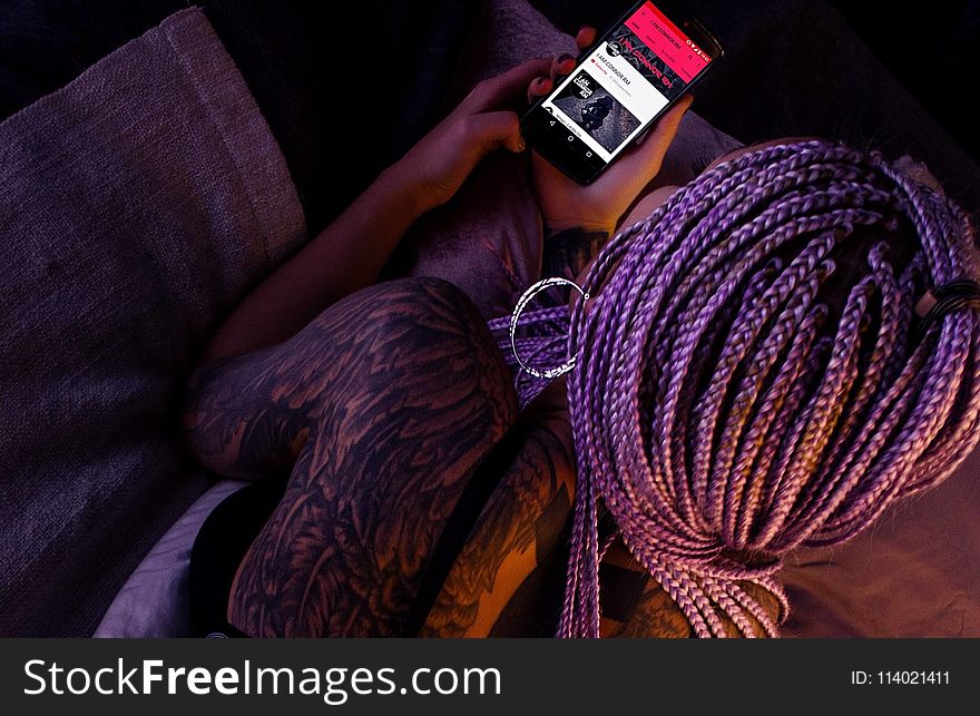 Woman with Purple Braided Hair Holding an Android Smartphone
