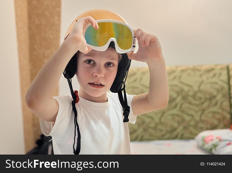 Portrait of laughing boy in skiing helmet playing at home