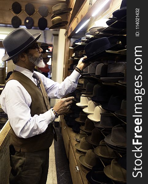 Man Picking Hats in Rack