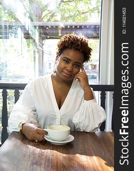 Woman Wearing White Deep V-neck Long-sleeved Blouse Holding White Ceramic Teacup