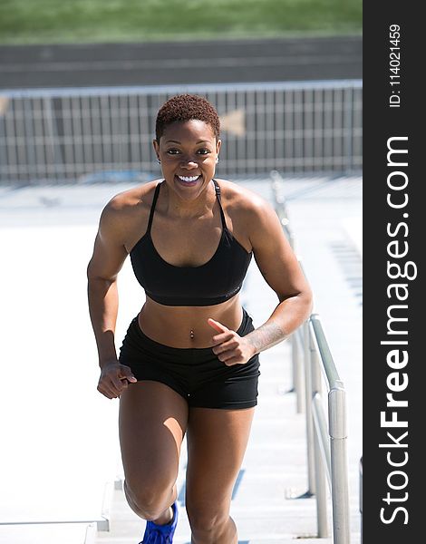 Woman Wearing Black Sports Bra and Jogger Shorts Smiling