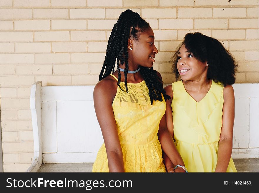 Two Girls Wearing Yellow Sleeveless Dresses
