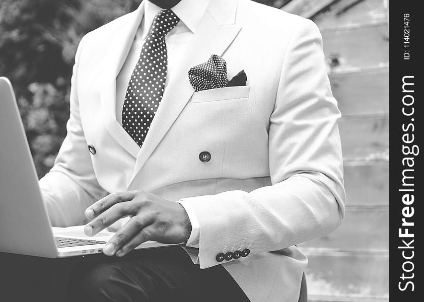 Grayscale Photo Of Man Wearing White Suit Jacket