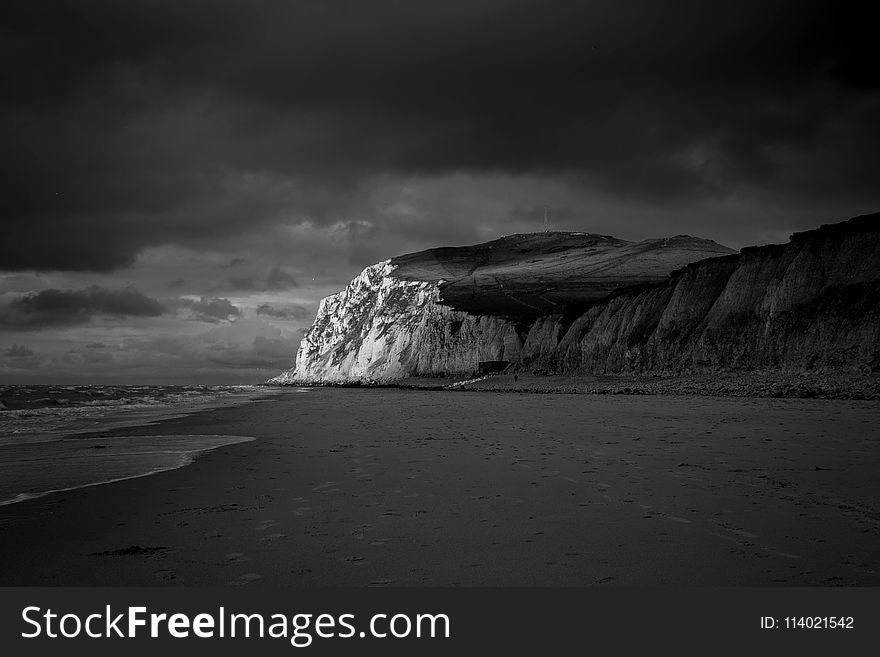 Mountain Near Beach Shore Under Dark Cloudy Sky