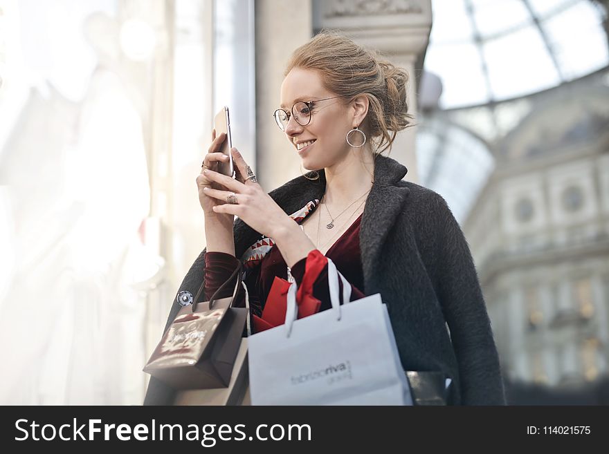 Woman Standing Near Wall Holding Phone