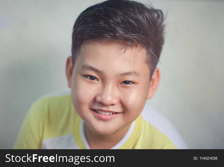 Close-up Photography of Boy Wearing White and Yellow Shirt