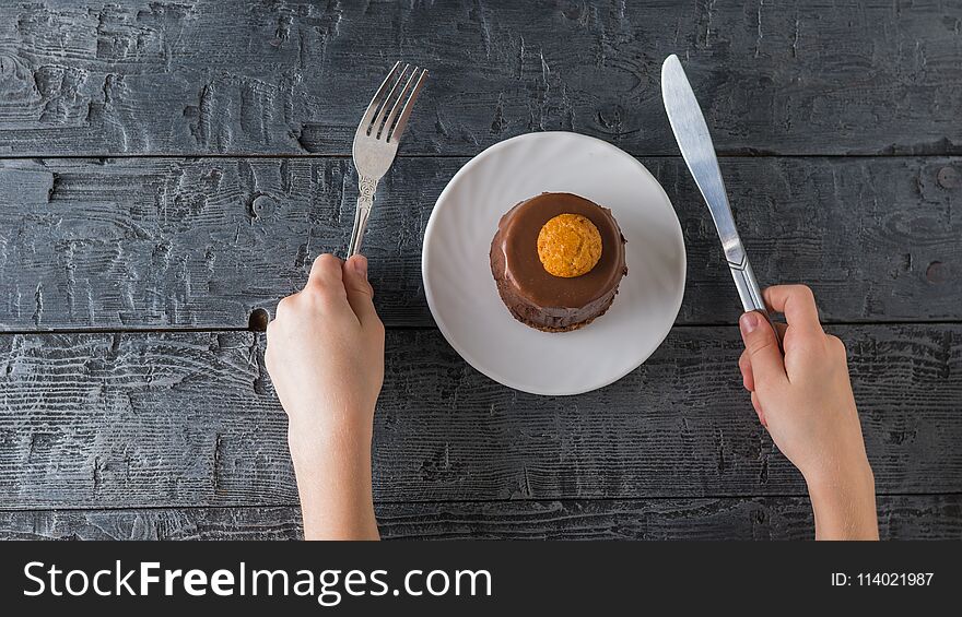 The child tries to eat dessert with a knife and fork.