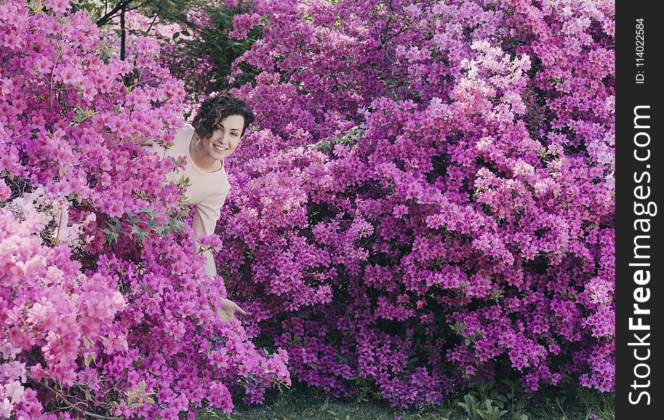 Beautiful girl and flowering rhododendron