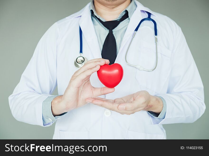 Doctor holding heart on background of Hospital ward.